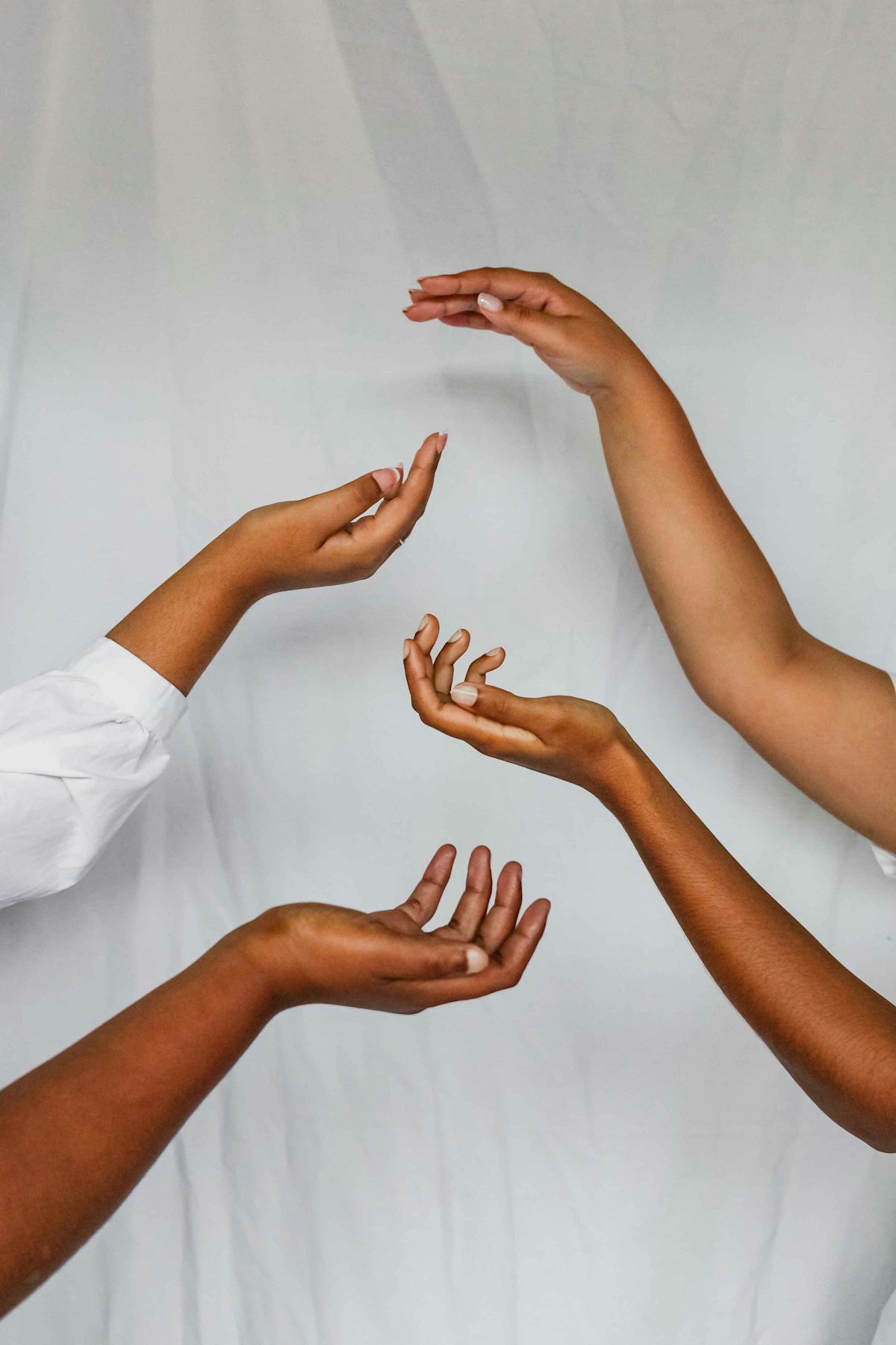 Women's hands reaching toward each other in a circle