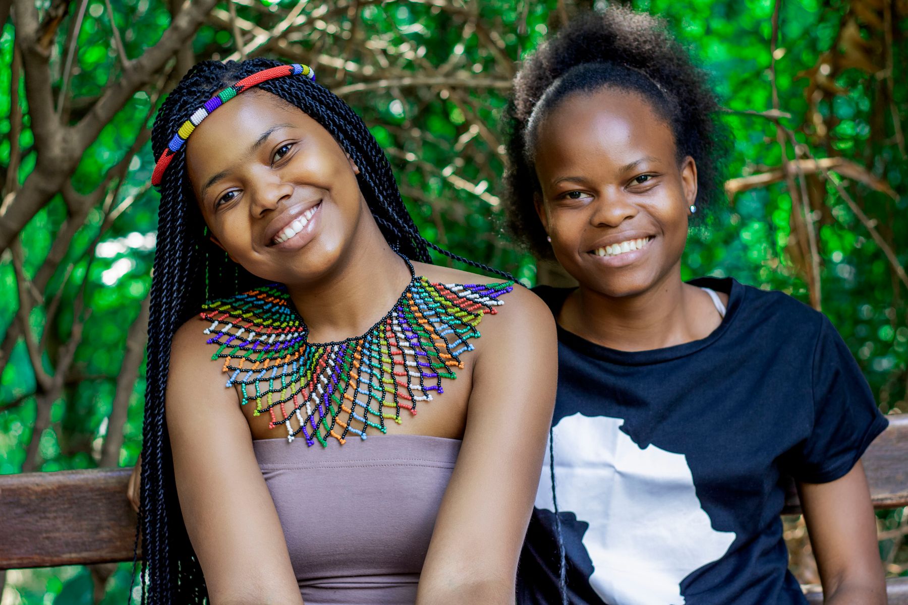 Two South African women smiling together, one wearing Zulu beadwork